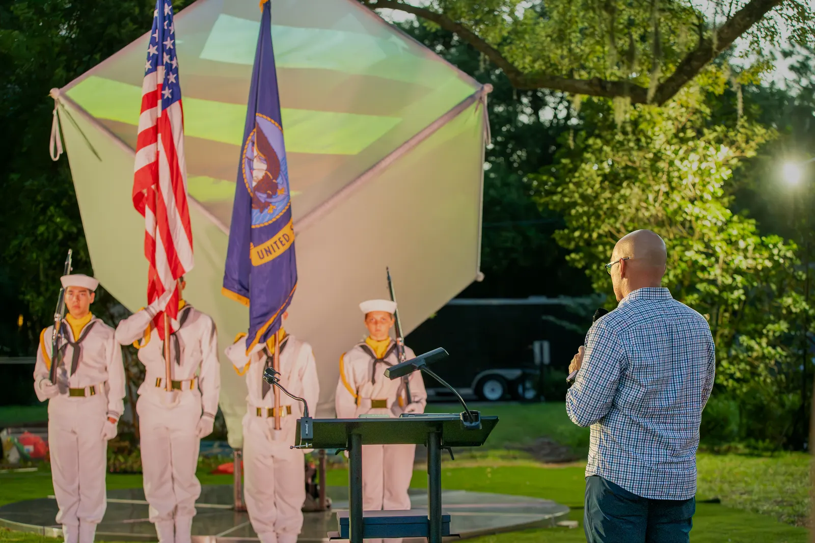 A man stands facing the flags during the formal ceremony.