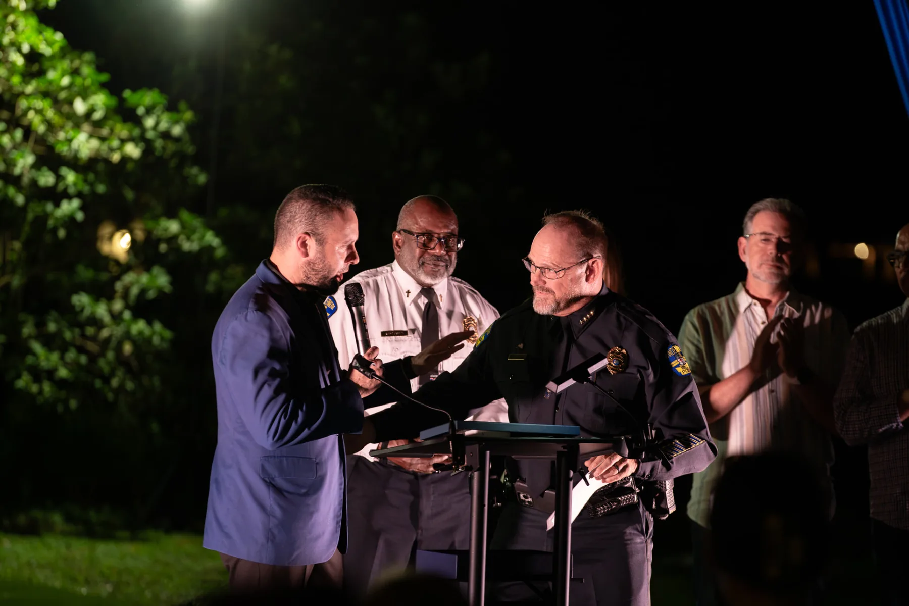 Chief David Ogden receives his award during the recognition ceremony as guests applaud.