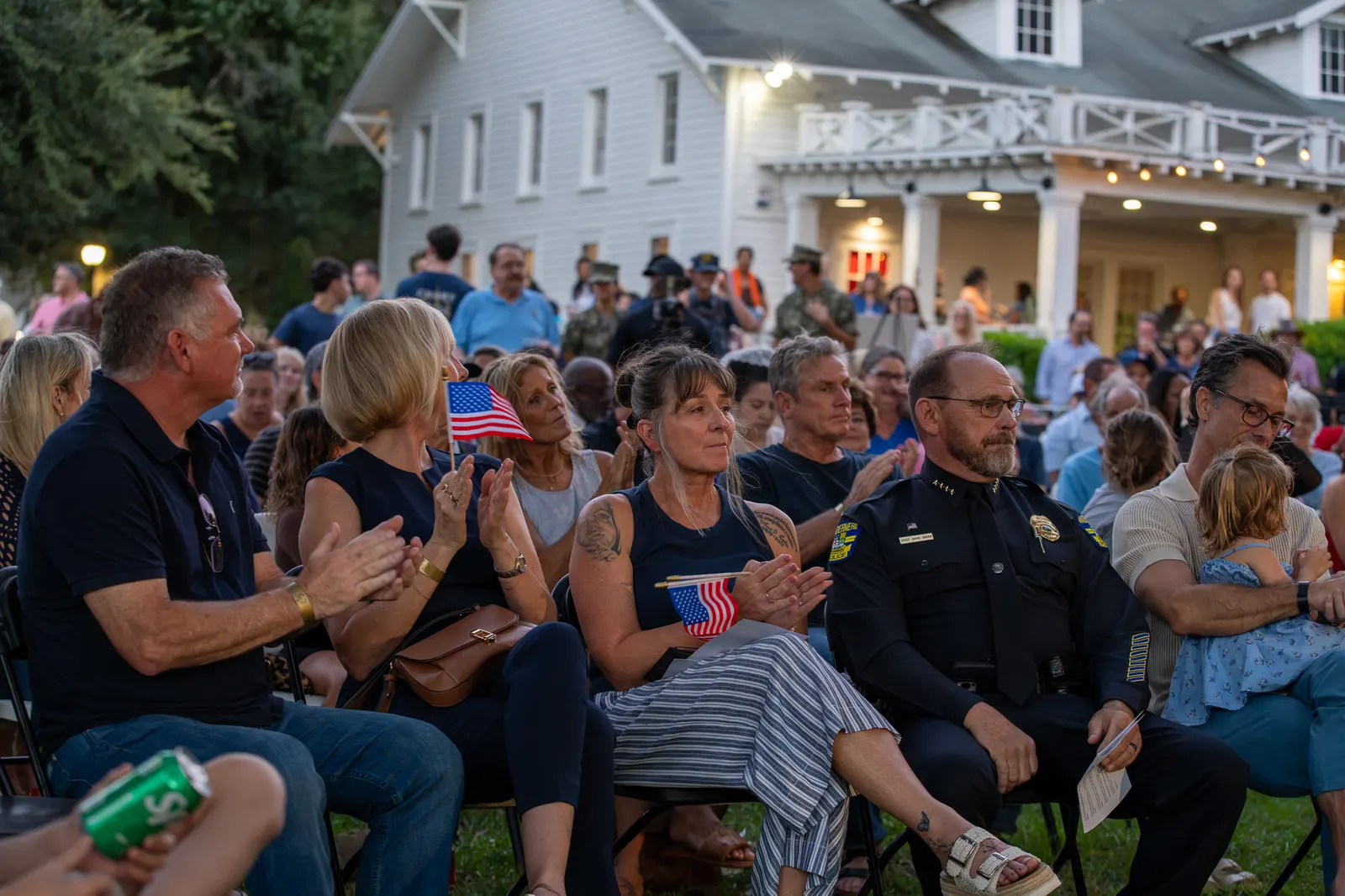 Front-row guests applaud during the outdoor ceremony.