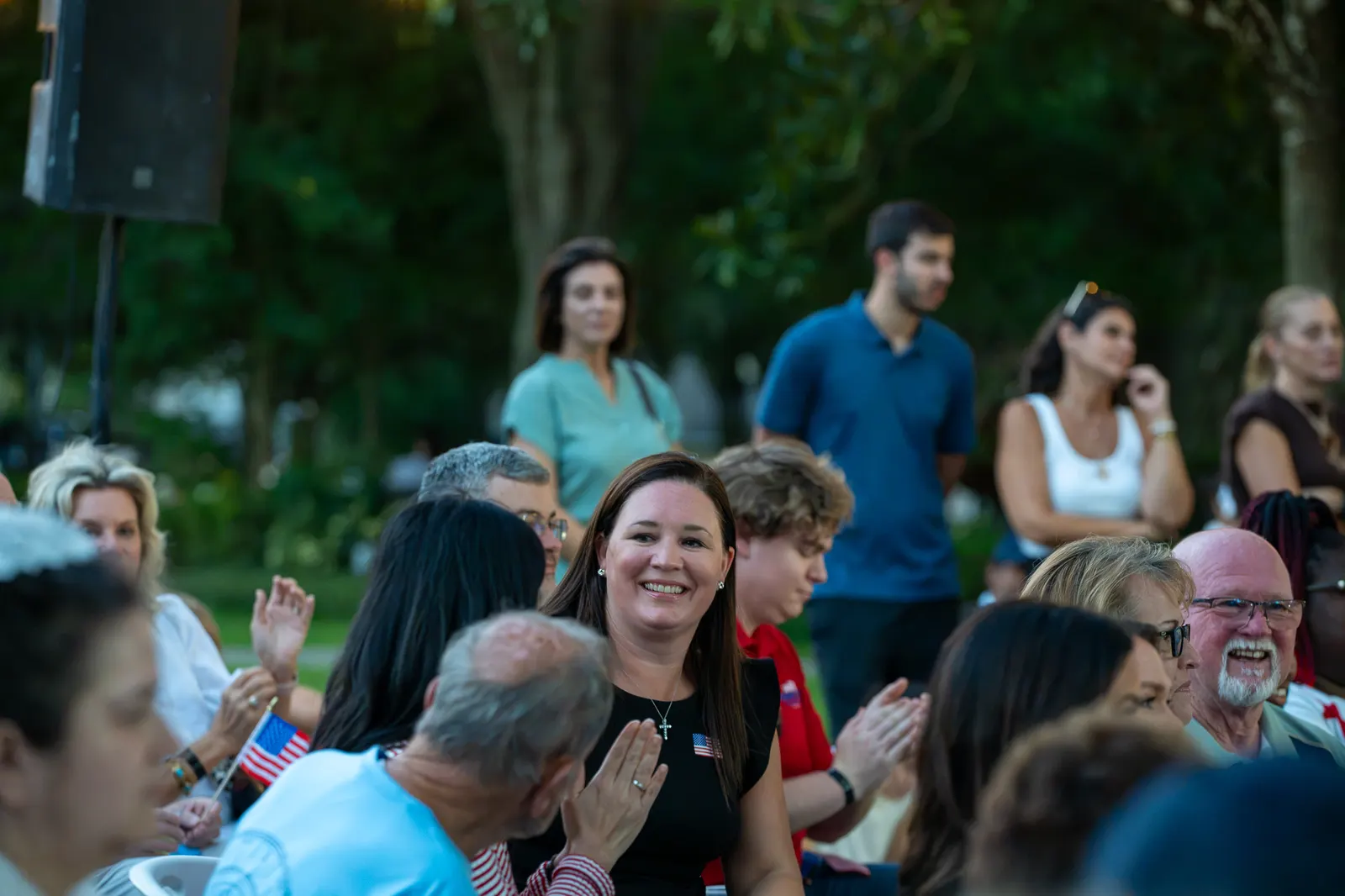 Audience members smile and talk between remarks.