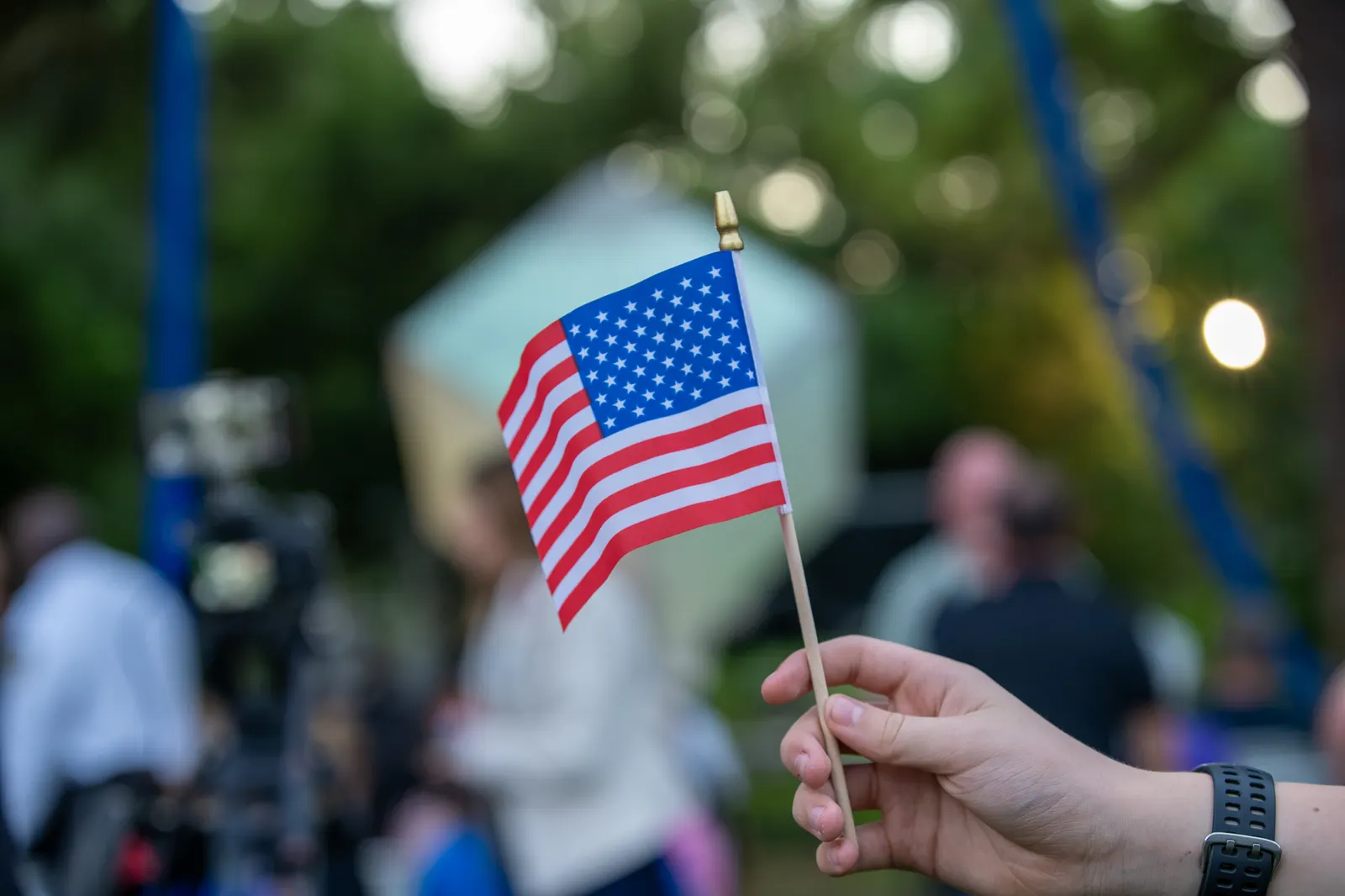 A guest holds a small American flag above the seated crowd.