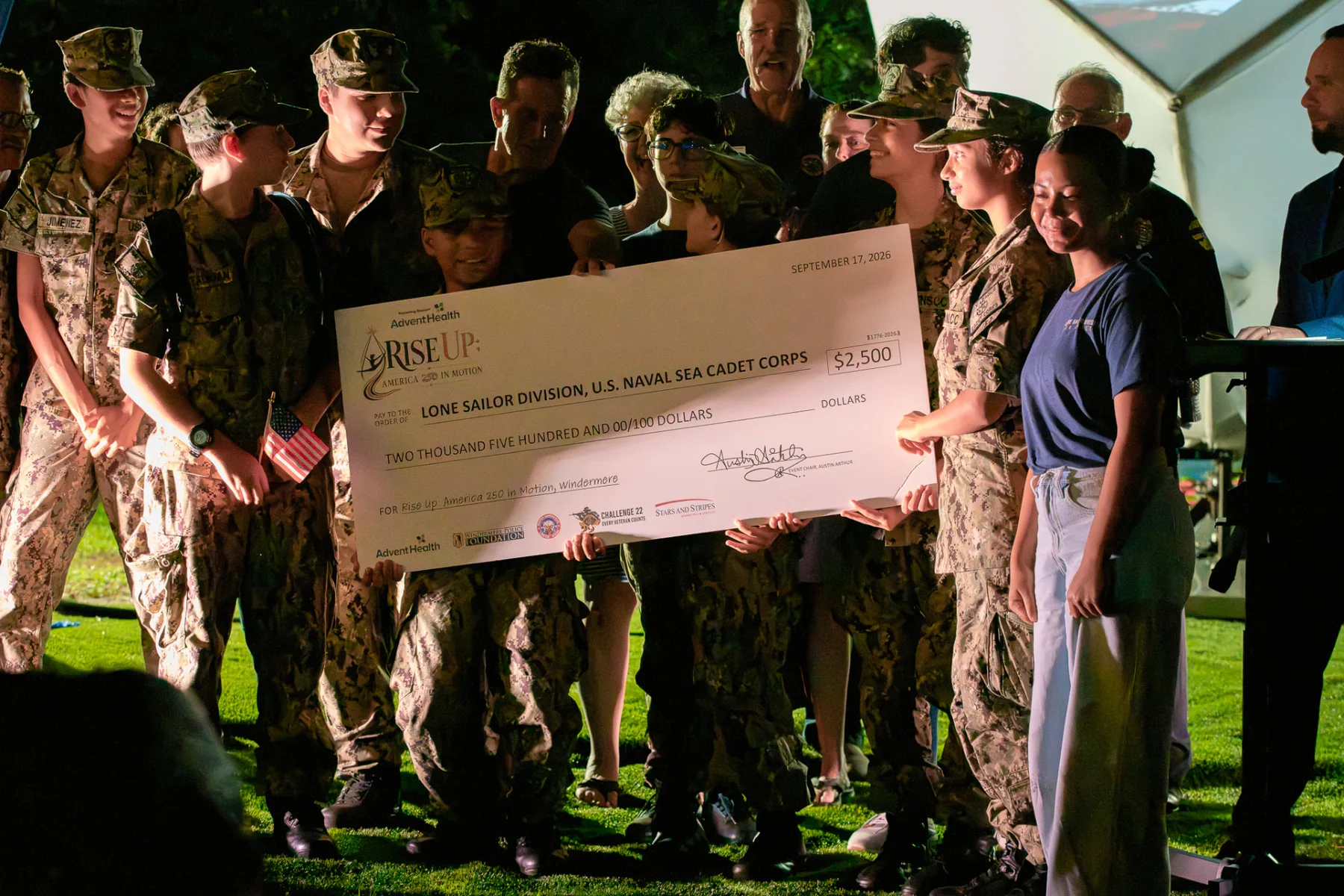 Lone Sailor Division Sea Cadets and community members gather around a ceremonial check for $2,500.