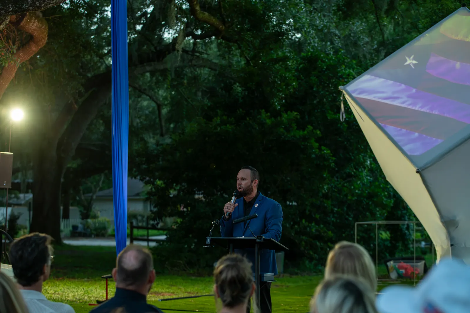 A speaker appears beside the glowing cube under a bright event light.