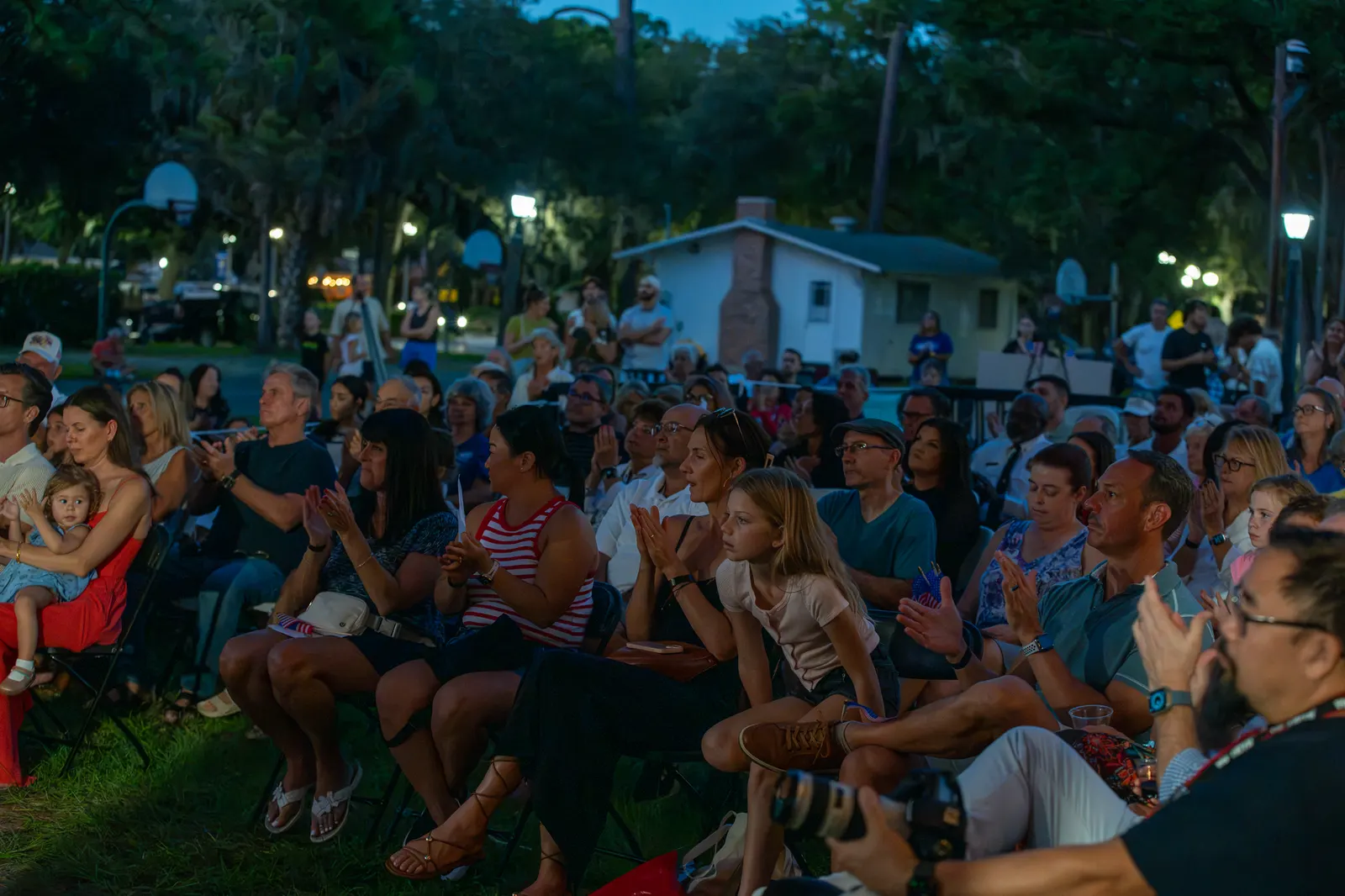 Rows of guests fill the lawn during the nighttime program.