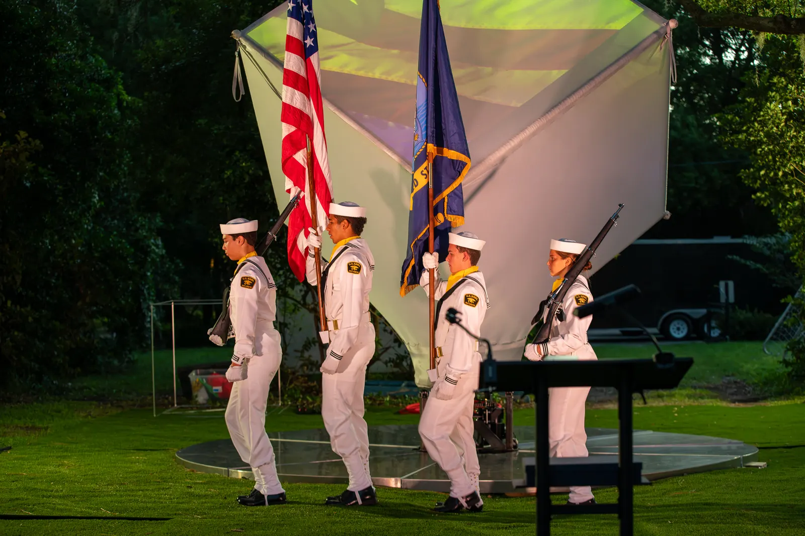 Uniformed Sea Cadets carry flags into the ceremony area.