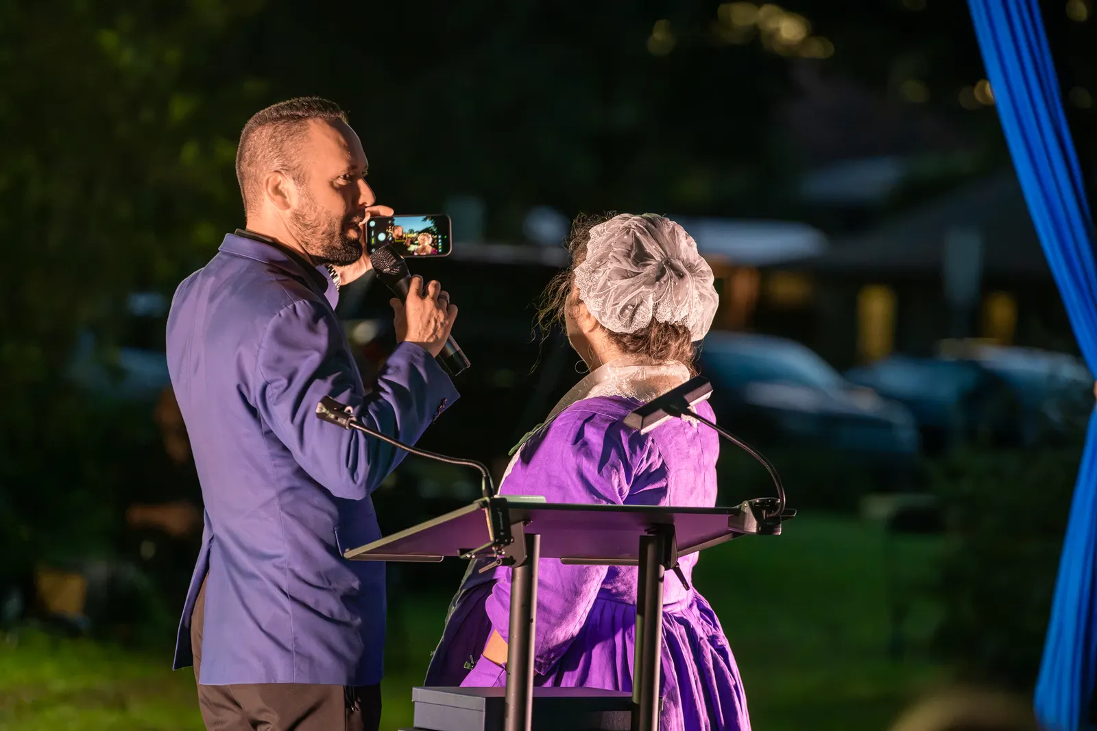 A man and an older woman speak together at the lectern.