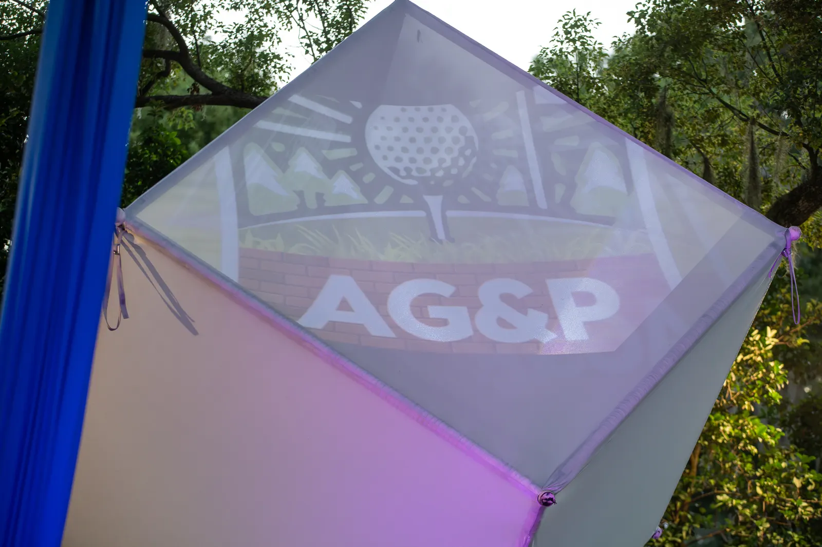 The illuminated performance cube displays an Artificial Grass and Pavers logo.