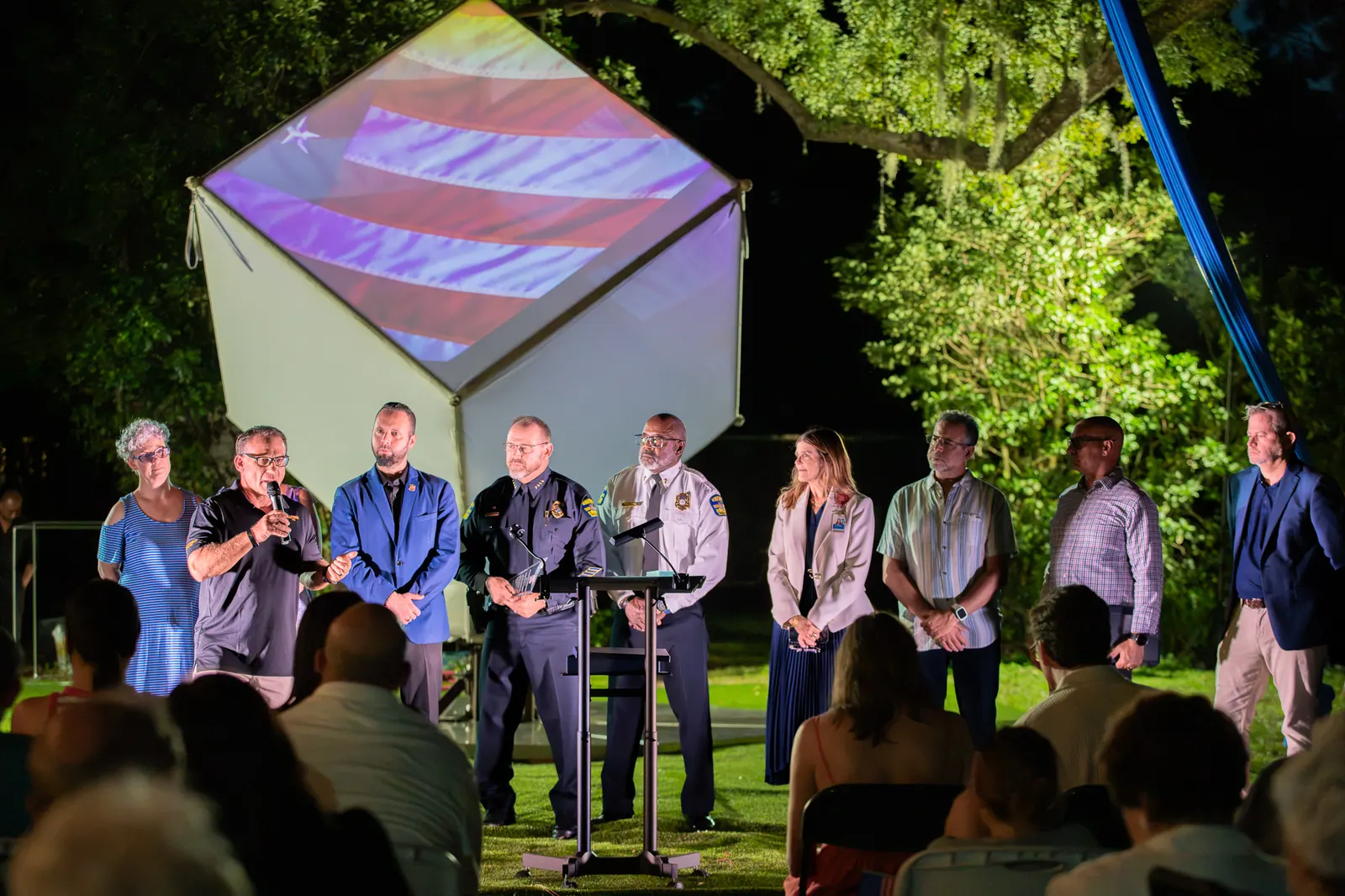 A large line of honorees faces the audience under stage lighting.