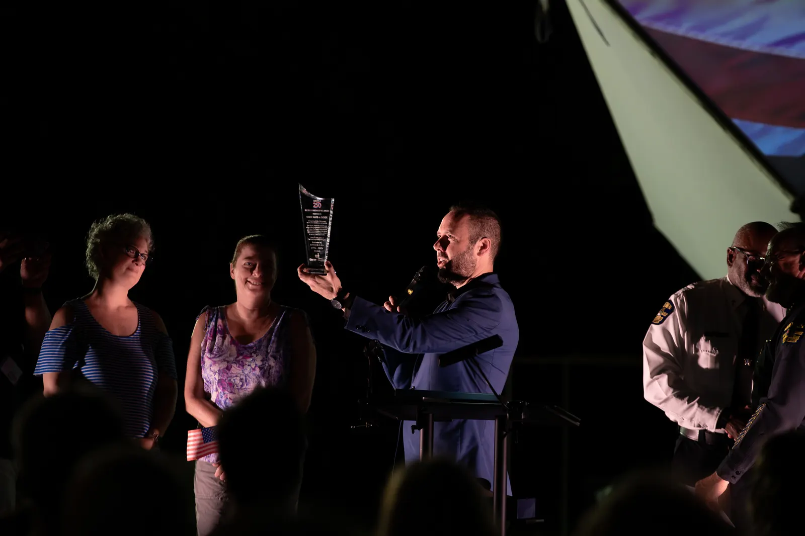 A presenter points across the stage while the group watches.